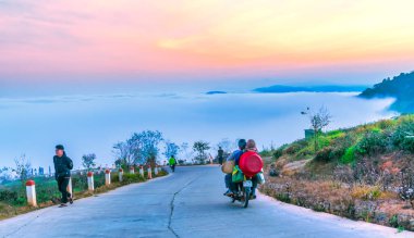 Da Lat, Vietnam - 21 Şubat 2024: Vietnam 'ın Da Lat kentindeki çiğ kaplı tepeleri ve dağları hayranlıkla seyreden birçok turist ve motorsikletle sabah platoda trafiği geçmek