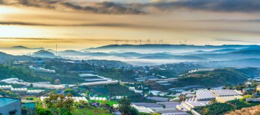 The morning landscape in the valley Da Lat, Vietnam with fog covered and sunrise background is so blurry, so beautiful and peaceful clipart