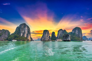 Halong Körfezi 'nin rüya gibi günbatımı manzarası, Çayırdan Vietnam manzarası. Burası UNESCO Dünya Mirası Alanı. Kuzey Vietnam 'da çok güzel bir doğa harikası.