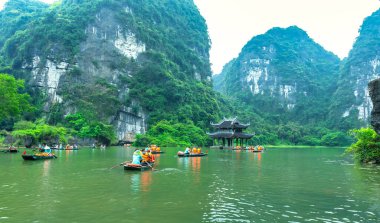 Ninh Binh, Vietnam - 5 Nisan 2024: Turistler Tam Coc Ulusal Parkı turu için tam Coc Nehri üzerinde mağaralara tekne ile yüzerler. Trang An, Ninh Binh, Vietnam.