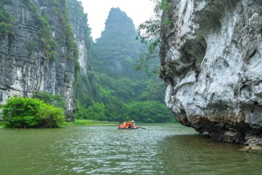 Ninh Binh, Vietnam - 5 Nisan 2024: Turistler Tam Coc Ulusal Parkı turu için tam Coc Nehri üzerinde mağaralara tekne ile yüzerler. Trang An, Ninh Binh, Vietnam.