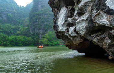 Ninh Binh, Vietnam - 5 Nisan 2024: Turistler Tam Coc Ulusal Parkı turu için tam Coc Nehri üzerinde mağaralara tekne ile yüzerler. Trang An, Ninh Binh, Vietnam.