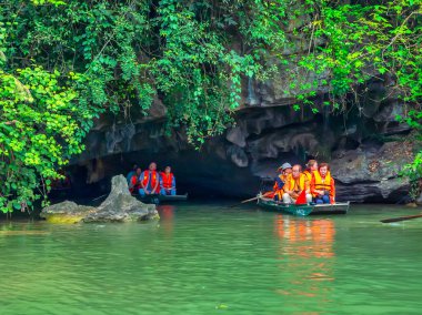 Ninh Binh, Vietnam - 5 Nisan 2024: Turistler Tam Coc Ulusal Parkı turu için tam Coc Nehri üzerinde mağaralara tekne ile yüzerler. Trang An, Ninh Binh, Vietnam.