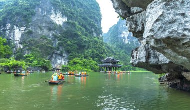 Ninh Binh, Vietnam - April 5th, 2024: Tourists float by boat on the river of the Tam Coc National Park Sightseeing tour to grottoes. Trang An, Ninh Binh, Vietnam. clipart