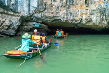 Ninh Binh, Vietnam - 5 Nisan 2024: Turistler Tam Coc Ulusal Parkı turu için tam Coc Nehri üzerinde mağaralara tekne ile yüzerler. Trang An, Ninh Binh, Vietnam.