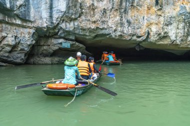 Ninh Binh, Vietnam - 5 Nisan 2024: Turistler Tam Coc Ulusal Parkı turu için tam Coc Nehri üzerinde mağaralara tekne ile yüzerler. Trang An, Ninh Binh, Vietnam.