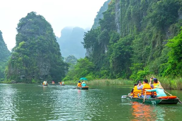 Ninh Binh, Vietnam - 5 Nisan 2024: Turistler Tam Coc Ulusal Parkı turu için tam Coc Nehri üzerinde mağaralara tekne ile yüzerler. Trang An, Ninh Binh, Vietnam.