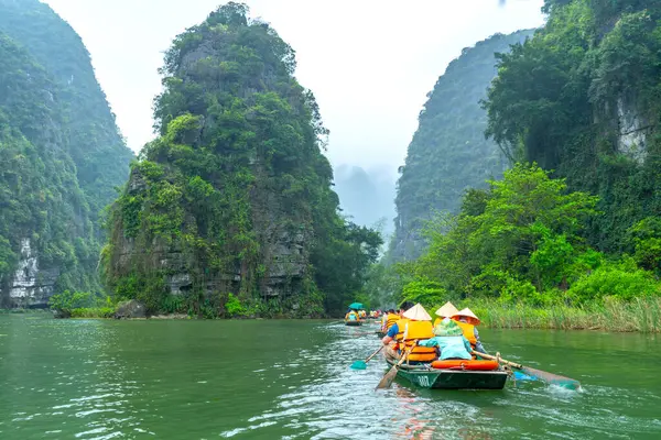 stock image Ninh Binh, Vietnam - April 5th, 2024: Tourists float by boat on the river of the Tam Coc National Park Sightseeing tour to grottoes. Trang An, Ninh Binh, Vietnam.