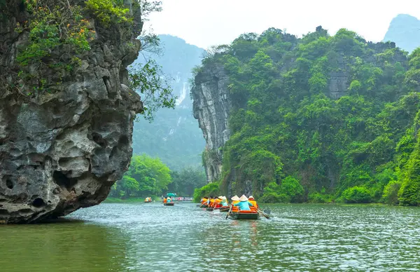 Ninh Binh, Vietnam - 5 Nisan 2024: Turistler Tam Coc Ulusal Parkı turu için tam Coc Nehri üzerinde mağaralara tekne ile yüzerler. Trang An, Ninh Binh, Vietnam.