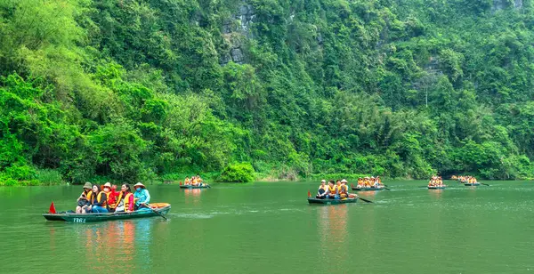 stock image Ninh Binh, Vietnam - April 5th, 2024: Tourists float by boat on the river of the Tam Coc National Park Sightseeing tour to grottoes. Trang An, Ninh Binh, Vietnam.