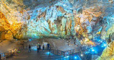 Quang Binh, Vietnam - 7 Nisan 2024: Turistler, Vietnam, Quang Binh, Vietnam 'daki Phong Nha ulusal parkında sarkıt ve dikitlerle birlikte doğal koridor Cennet Mağarası' nı ziyaret ettiler.