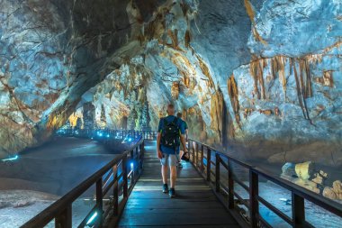 Quang Binh, Vietnam - 7 Nisan 2024: Turistler, Vietnam, Quang Binh, Vietnam 'daki Phong Nha ulusal parkında sarkıt ve dikitlerle birlikte doğal koridor Cennet Mağarası' nı ziyaret ettiler.