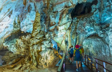 Quang Binh, Vietnam - 7 Nisan 2024: Turistler, Vietnam, Quang Binh, Vietnam 'daki Phong Nha ulusal parkında sarkıt ve dikitlerle birlikte doğal koridor Cennet Mağarası' nı ziyaret ettiler.