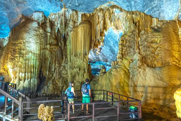 stock image Quang Binh, Vietnam - April 7th, 2024: Tourists visit on wooden walkway through scenic natural corridor Paradise Cave with stalactites and stalagmites in Phong Nha national park, Quang Binh, Vietnam
