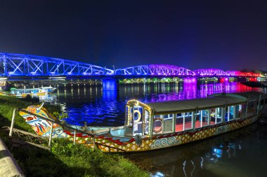 Hue, Vietnam - 10 Nisan 2024 Hue City 'deki Truong Tien Köprüsü panoramik manzarası. Köprü, suyun bulanık yansımasıyla aydınlandı.