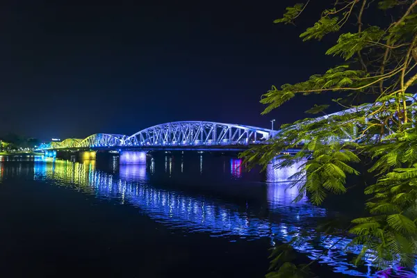 stock image Hue, Vietnam - April 10th, 2024: Panoramic view of Truong Tien Bridge in Hue City at night. Bridge illuminated all over with blurry reflection on water