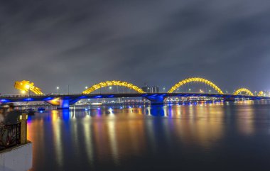 Da Nang, Vietnam - 15 Nisan 2024: Dragon River Köprüsü ve geceleri idari merkez binası, Da Nang şehrinin sembolü. Da Nang Vietnam 'ın en yaşanabilir turistik şehridir.