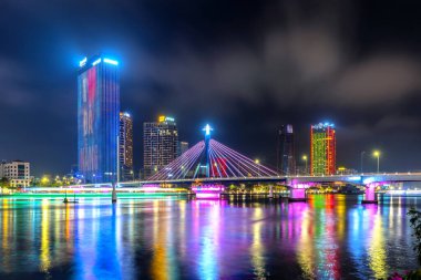 Da Nang, Vietnam - 15 Nisan 2024: Han Nehri Köprüsü ve geceleri yönetim merkezi binası, Da Nang şehrinin sembolü, Vietnam. Da Nang Vietnam 'ın en yaşanabilir turistik şehridir.