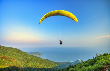 Da Nang, Vietnam - 15 Nisan 2024 Son Tra dağının tepesinden başlayan paragliding turnesi Da Nang plajına ulaştı.