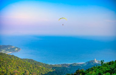 Da Nang, Vietnam - 15 Nisan 2024 Son Tra dağının tepesinden başlayan paragliding turnesi Da Nang plajına ulaştı.