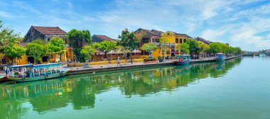 Hoi An, Vietnam - 16 Nisan 2024: Hoi An 'ın nehir kıyısındaki antik şehir manzarası, klasik binalar. Burası, karışık kültür ve mimarisi ile ünlü Dünya Kültür Mirası Bölgesi..