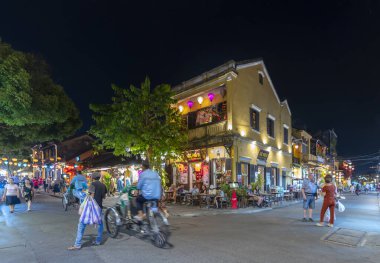 Hoi An, Vietnam - 17 Nisan 2024: Old Town Hoi An 'daki işlek caddenin gece manzarası. Hoi An, karışık kültür ve mimarisi ile ünlü Dünya Kültür Mirası sitesidir..