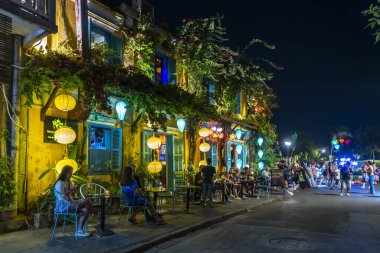 Hoi An, Vietnam - 17 Nisan 2024: Old Town Hoi An 'daki işlek caddenin gece manzarası. Hoi An, karışık kültür ve mimarisi ile ünlü Dünya Kültür Mirası sitesidir..