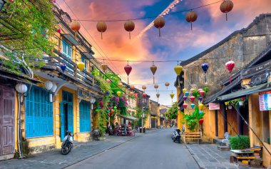 Hoi An, Vietnam - 16 Nisan 2024: Trajik, süslü ipek fenerlerin olduğu manzara sabahı, inanılmaz geleneksel sarı evler. Tarihi eski Hoi An kasabası 1999 yılından bu yana UNESCO 'nun Dünya Mirası Alanında yer alıyor.. 