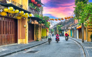 Hoi An, Vietnam - 16 Nisan 2024: Trajik, süslü ipek fenerlerin olduğu manzara sabahı, inanılmaz geleneksel sarı evler. Tarihi eski Hoi An kasabası 1999 yılından bu yana UNESCO 'nun Dünya Mirası Alanında yer alıyor.. 