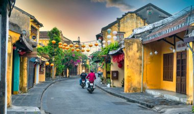 Hoi An, Vietnam - 16 Nisan 2024: Trajik, süslü ipek fenerlerin olduğu manzara sabahı, inanılmaz geleneksel sarı evler. Tarihi eski Hoi An kasabası 1999 yılından bu yana UNESCO 'nun Dünya Mirası Alanında yer alıyor.. 