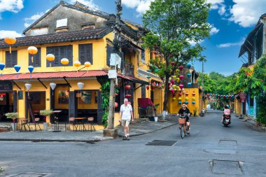 Hoi An, Vietnam - 16 Nisan 2024: Trajik, süslü ipek fenerlerin olduğu manzara sabahı, inanılmaz geleneksel sarı evler. Tarihi eski Hoi An kasabası 1999 yılından bu yana UNESCO 'nun Dünya Mirası Alanında yer alıyor.. 