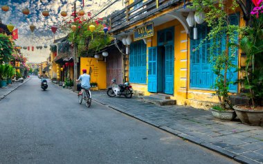 Hoi An, Vietnam - 16 Nisan 2024: Trajik, süslü ipek fenerlerin olduğu manzara sabahı, inanılmaz geleneksel sarı evler. Tarihi eski Hoi An kasabası 1999 yılından bu yana UNESCO 'nun Dünya Mirası Alanında yer alıyor.. 