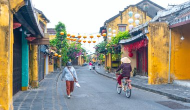 Hoi An, Vietnam - 16 Nisan 2024: Trajik, süslü ipek fenerlerin olduğu manzara sabahı, inanılmaz geleneksel sarı evler. Tarihi eski Hoi An kasabası 1999 yılından bu yana UNESCO 'nun Dünya Mirası Alanında yer alıyor.. 