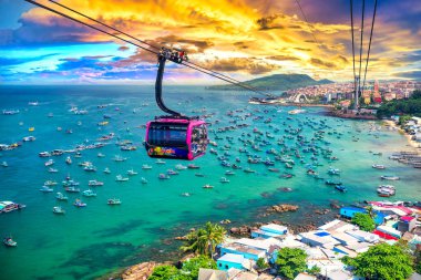 Dünyanın en uzun teleferik yolculuğu Güney Vietnam 'daki Phu Quoc adası, günbatımı gökyüzü. Aşağıda, popüler Hon Thom adasındaki An Thoi kasabasının limanında sıralanmış geleneksel balıkçı tekneleri var..