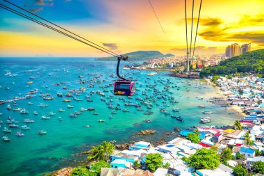 Dünyanın en uzun teleferik yolculuğu Güney Vietnam 'daki Phu Quoc adası, günbatımı gökyüzü. Aşağıda, popüler Hon Thom adasındaki An Thoi kasabasının limanında sıralanmış geleneksel balıkçı tekneleri var..