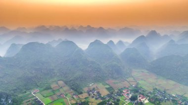 Dağların büyülü manzarası birbirini takip eden mesajı andırıyor. Şafak vakti Bac Son Bölgesi Lang Son, Vietnam 'da yemyeşil bitki örtüsü tabakaları ile kaplandılar.