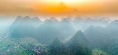 Dağların büyülü manzarası birbirini takip eden mesajı andırıyor. Şafak vakti Bac Son Bölgesi Lang Son, Vietnam 'da yemyeşil bitki örtüsü tabakaları ile kaplandılar.