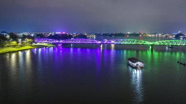 Hue City 'nin hava manzarası, Vietnam geceleri. Köprü, suyun bulanık yansımasıyla aydınlandı.