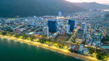 Quy Nhon, Vietnam - 18 Nisan 2024: Quy Nhon kıyı kenti güzel şehri ve temiz kumlu plajı ile geceleyin yukarıdan görülen Quy Nhon turistleri Quy Nhon, Vietnam 'a davet ediyor.