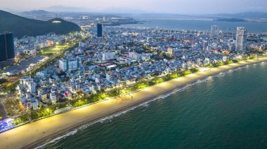 Quy Nhon, Vietnam - 18 Nisan 2024: Quy Nhon kıyı kenti güzel şehri ve temiz kumlu plajı ile geceleyin yukarıdan görülen Quy Nhon turistleri Quy Nhon, Vietnam 'a davet ediyor.