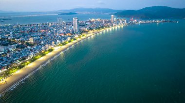 Quy Nhon, Vietnam - 18 Nisan 2024: Quy Nhon kıyı kenti güzel şehri ve temiz kumlu plajı ile geceleyin yukarıdan görülen Quy Nhon turistleri Quy Nhon, Vietnam 'a davet ediyor.