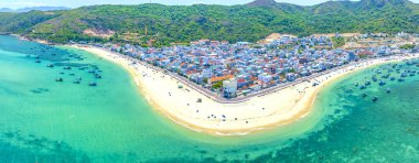 Binh Dinh Eyaleti, Vietnam 'da bir balıkçı köyünün ve geleneksel balıkçı teknesinin hava manzarası..
