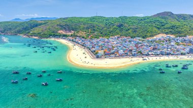 Binh Dinh Eyaleti, Vietnam 'da bir balıkçı köyünün ve geleneksel balıkçı teknesinin hava manzarası..