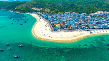 Binh Dinh Eyaleti, Vietnam 'da bir balıkçı köyünün ve geleneksel balıkçı teknesinin hava manzarası..