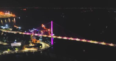 İnsansız hava aracı görüntüsü, Bai Chay köprüsünün gece görüşü Ha Long Şehri, Vietnam, gece trafiği.