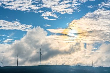 Rüzgâr türbinleri ve mavi gökyüzü olan güzel bir manzara.