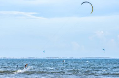 Yazın sahilde uçurtma uçuran bir adam.