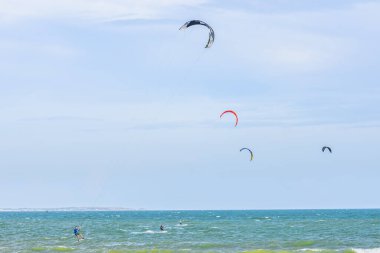 Mavi gökyüzünün arka planında, denizde uçurtma uçuyor.
