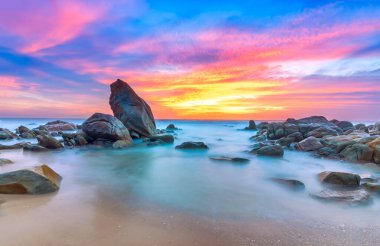 Sabahleyin kayalık sahilde gün doğumu