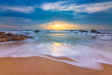 Güneşin doğuşu güzel denizin kumsalında